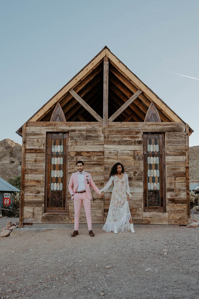 Couple pose next to small chapel before they elope in Nevada