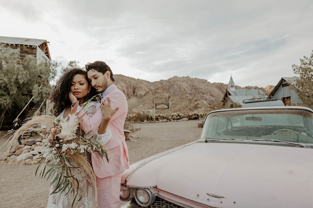 Couple poses next to car after they elope in Nevada