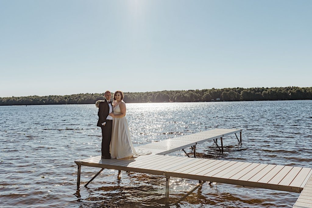 Bride and groom pose on pier for Wisconsin lakeside elopement