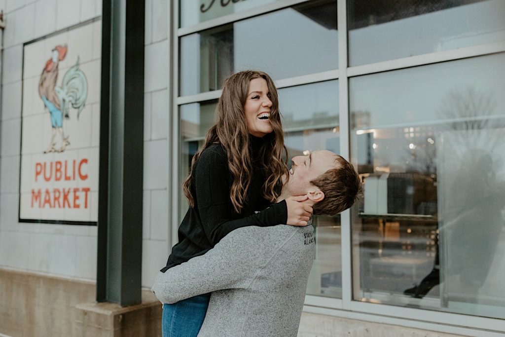 Couple laugh and hug for their engagement photo in downtown Milwaukee
