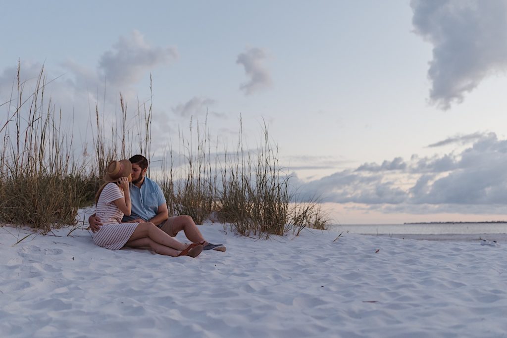 Couple kissing on the beach after engagement, photographed by destination photographer