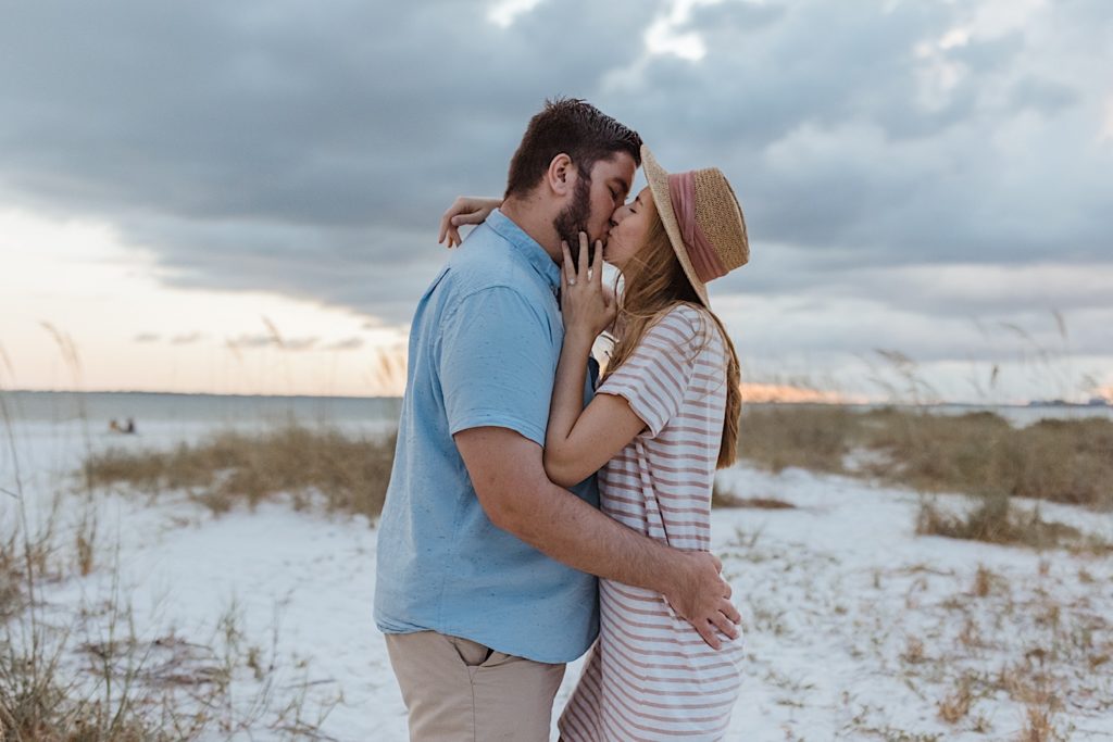 Couple kissing on the beach, photographed by destination photographer